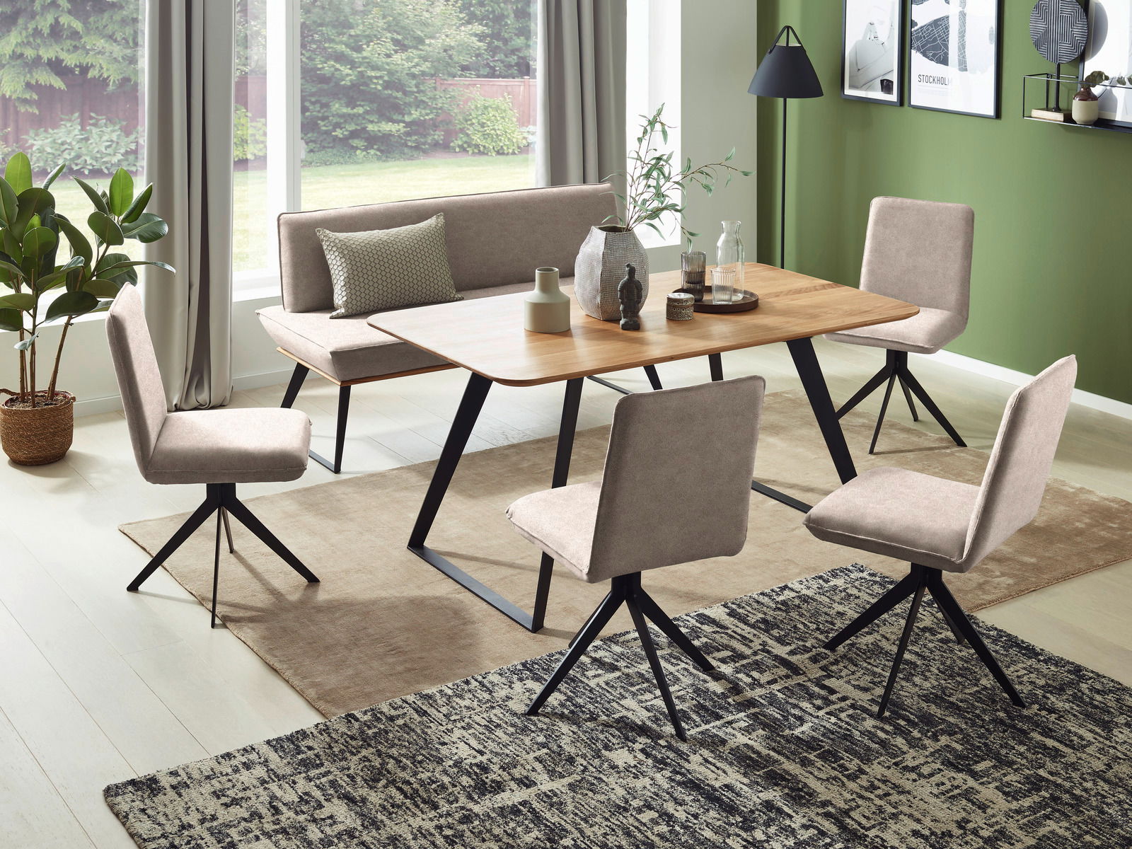 Esszimmer mit modernem Tisch und Bank in Holzoptik, umgeben von vier gepolsterten Stühlen. Die Perspektive zeigt den Raum von der Seite mit Blick auf die Fensterfront.