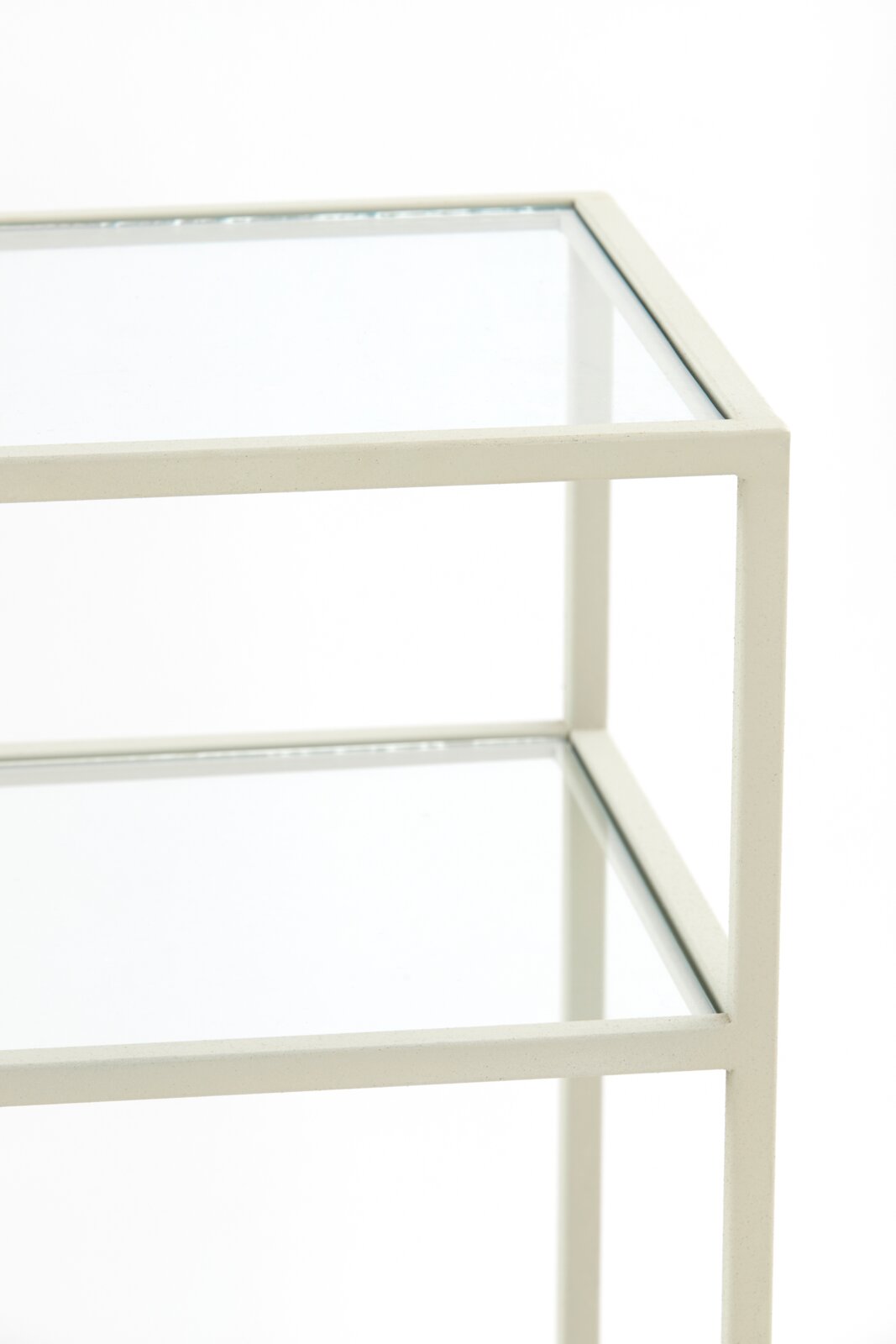 Close-up van een consoletafel met glazen bladen en een wit metalen frame, gezien vanaf de zijkant