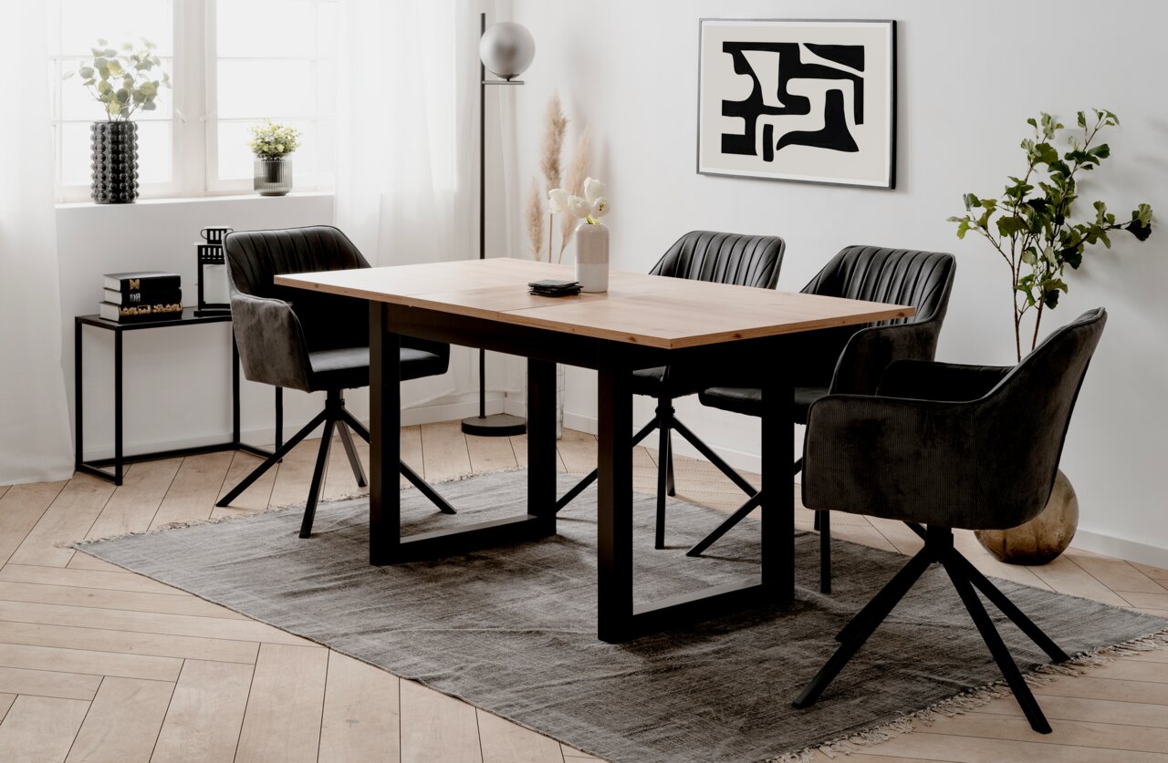 Moderne eettafel met houten blad en zwarte metalen poten, omringd door vier gestoffeerde stoelen in een stijlvol ingerichte ruimte. Zijaanzicht.