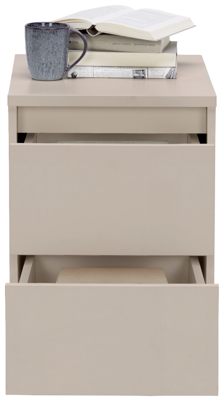 Beige Nachtkommode mit zwei offenen Schubladen, darauf Bücher und eine Tasse, Frontalansicht