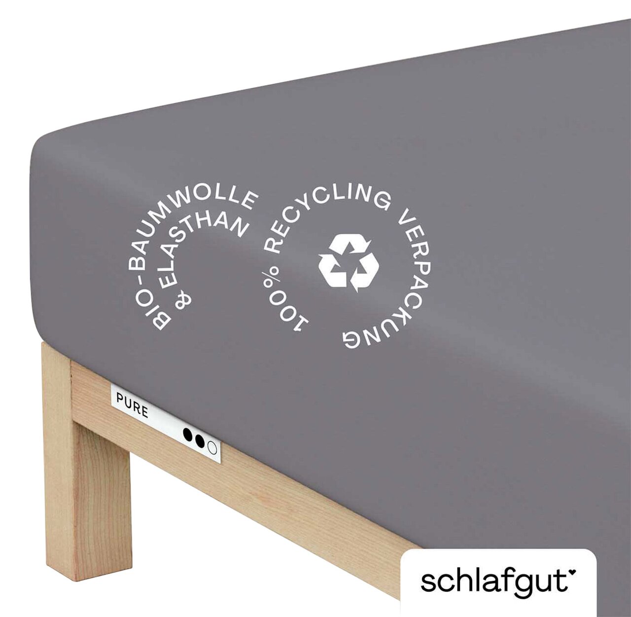 schlafgut Spannbettlaken XL 128 Pure Graues Spannbettlaken aus Bio-Baumwolle und Elasthan auf einem Bett, mit Recycling-Symbol, seitliche Perspektive
