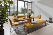 Moderne Esszimmer-Szene mit einem Holztisch, umgeben von senffarbenen Stühlen und Bänken, mit Blick auf große Fenster und viel Tageslicht.