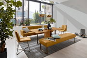 Moderne Esszimmer-Szene mit einem Holztisch, umgeben von senffarbenen Stühlen und Bänken, mit Blick auf große Fenster und viel Tageslicht.