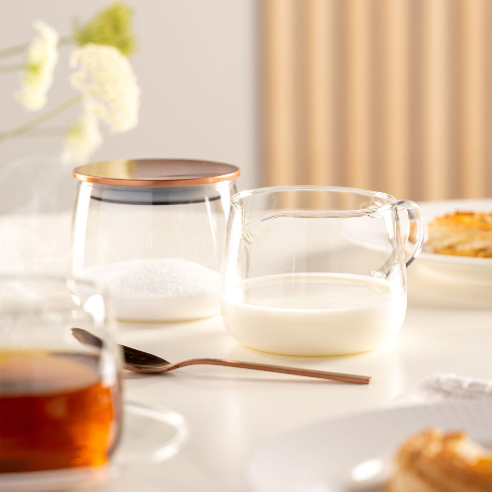 Glas-Milchkännchen TE PER TE 350ml auf einem Tisch, gefüllt mit Milch, in einer gemütlichen Frühstücksszene von vorne betrachtet.