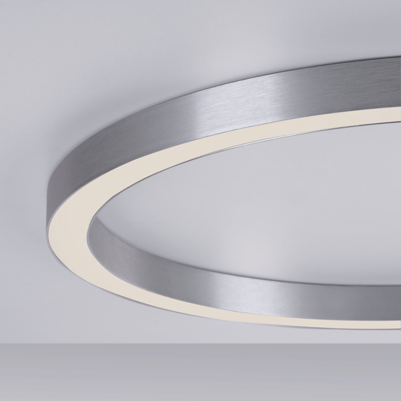Moderne Deckenleuchte PURE-LINES von Paul Neuhaus in seitlicher Perspektive, mit einem eleganten, runden Design und einem silbernen Rahmen.