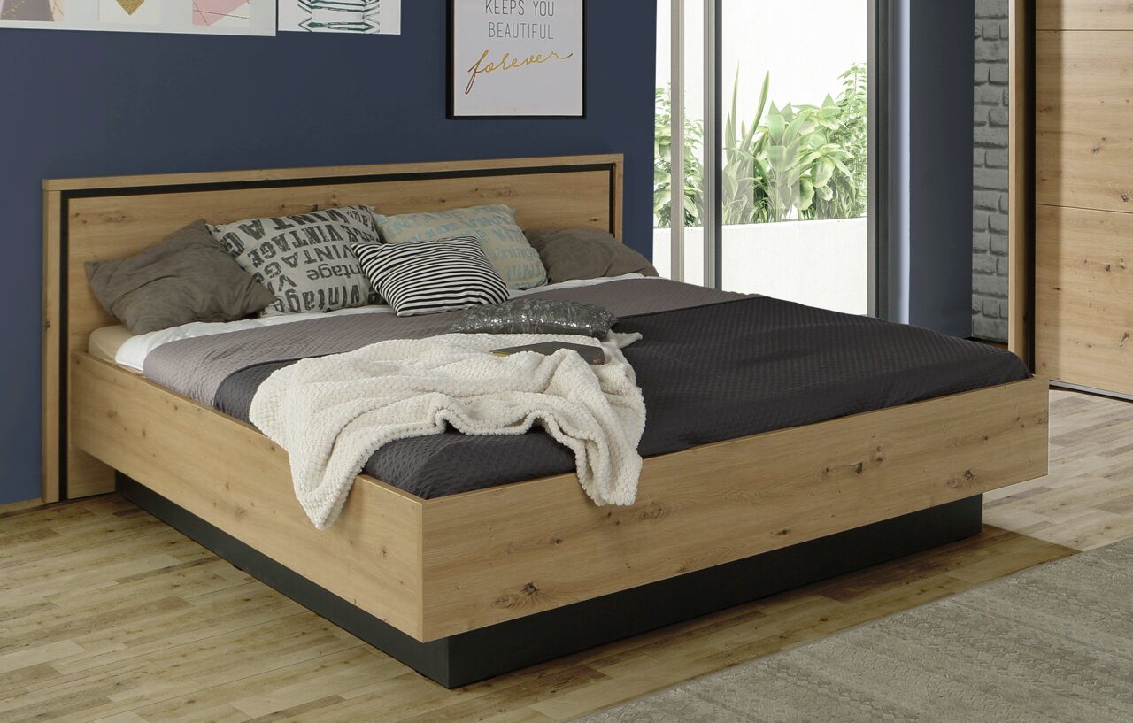 Modernes Doppelbett aus Holz mit gemütlicher Bettwäsche, seitliche Perspektive