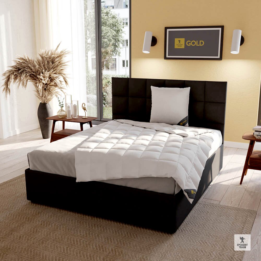 Spessarttraum Kissen GOLD Modernes Schlafzimmer mit einem eleganten, schwarzen Bett und einem Spessarttraum Kissen GOLD in der Größe 80x80cm, seitliche Perspektive.