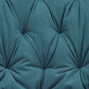 Nahaufnahme eines gepolsterten, gesteppten Stuhlbezugs in blauem Stoff mit feiner Rillenstruktur, von oben betrachtet.
