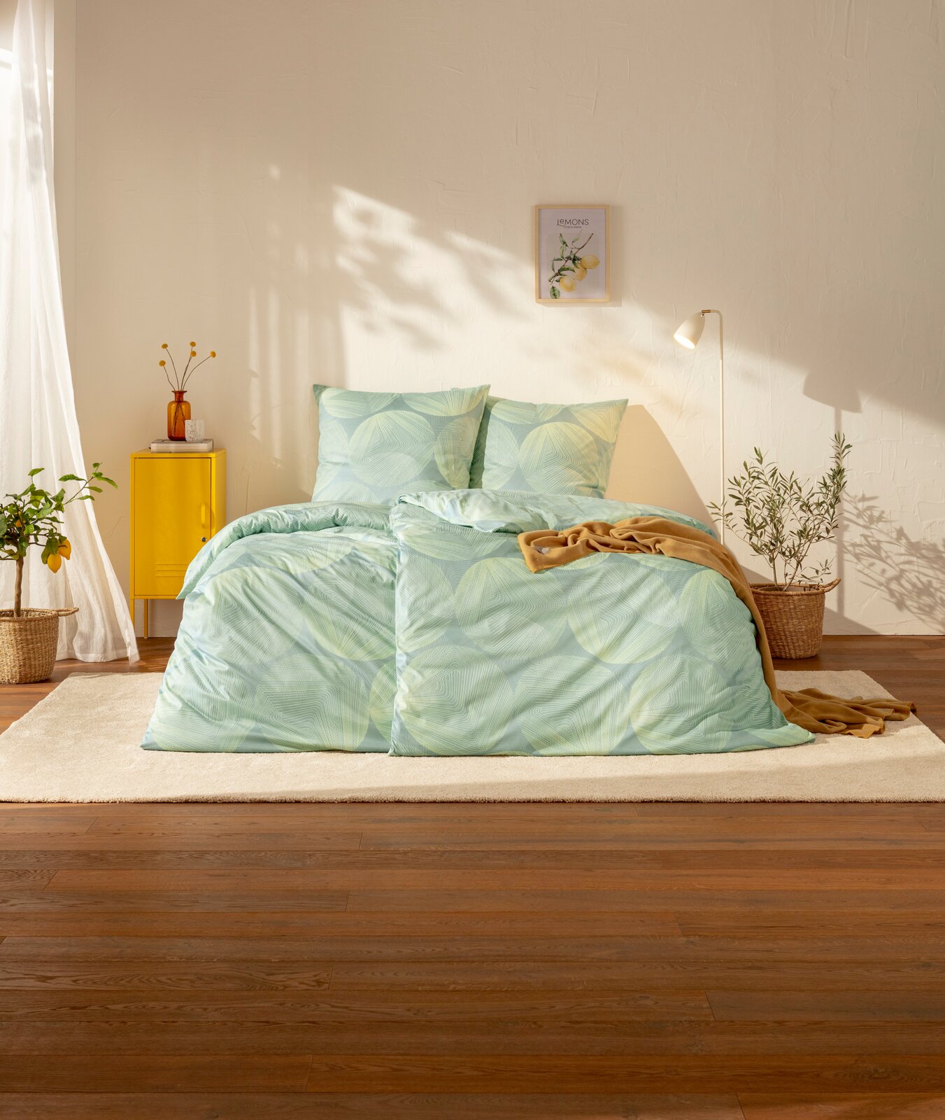 Estella Mako-Interlok-Jersey Bettwäsche 135/200cm DORA Mintgrüne Bettwäsche mit großem Blattmuster auf einem Bett in einem hellen Schlafzimmer, Frontansicht auf das Produkt