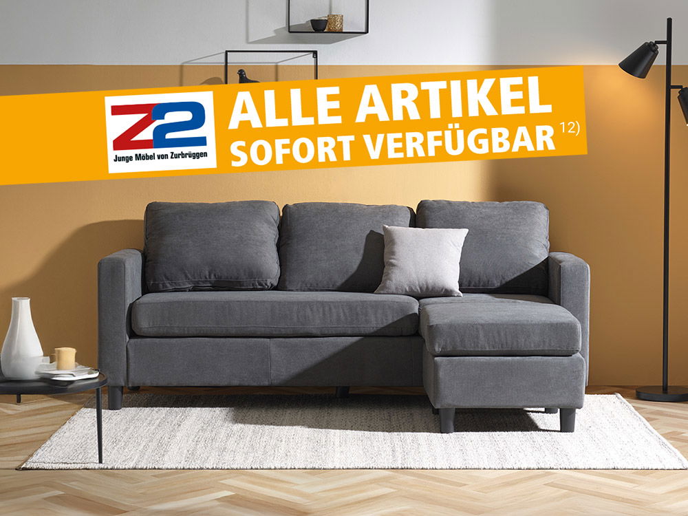 Graues Ecksofa in modernem Wohnzimmer mit gelber Wand, Teppich, Stehlampe und Wandregalen