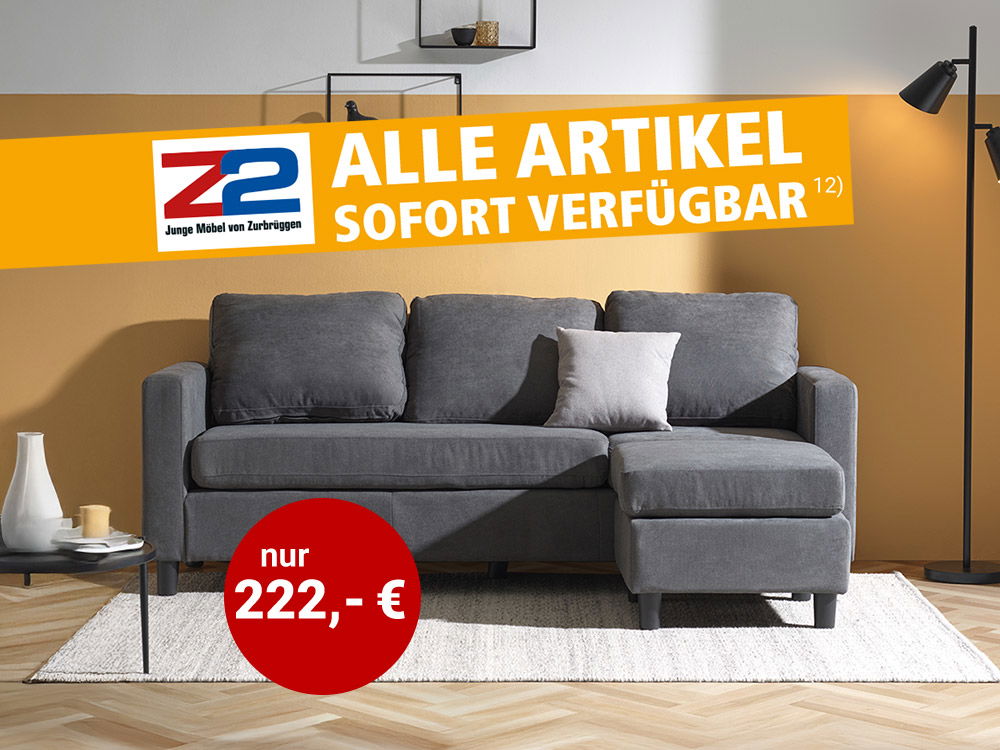 Graues Ecksofa in modernem Wohnzimmer mit gelber Wand, Teppich, Stehlampe und Wandregalen