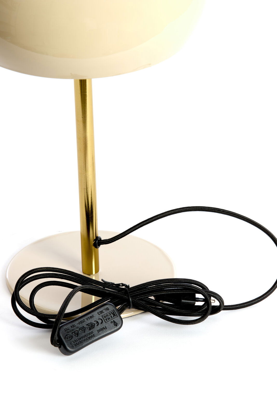 Nahaufnahme einer Tischleuchte mit einem goldenen Ständer und einem schwarzen Kabel auf weißem Hintergrund.