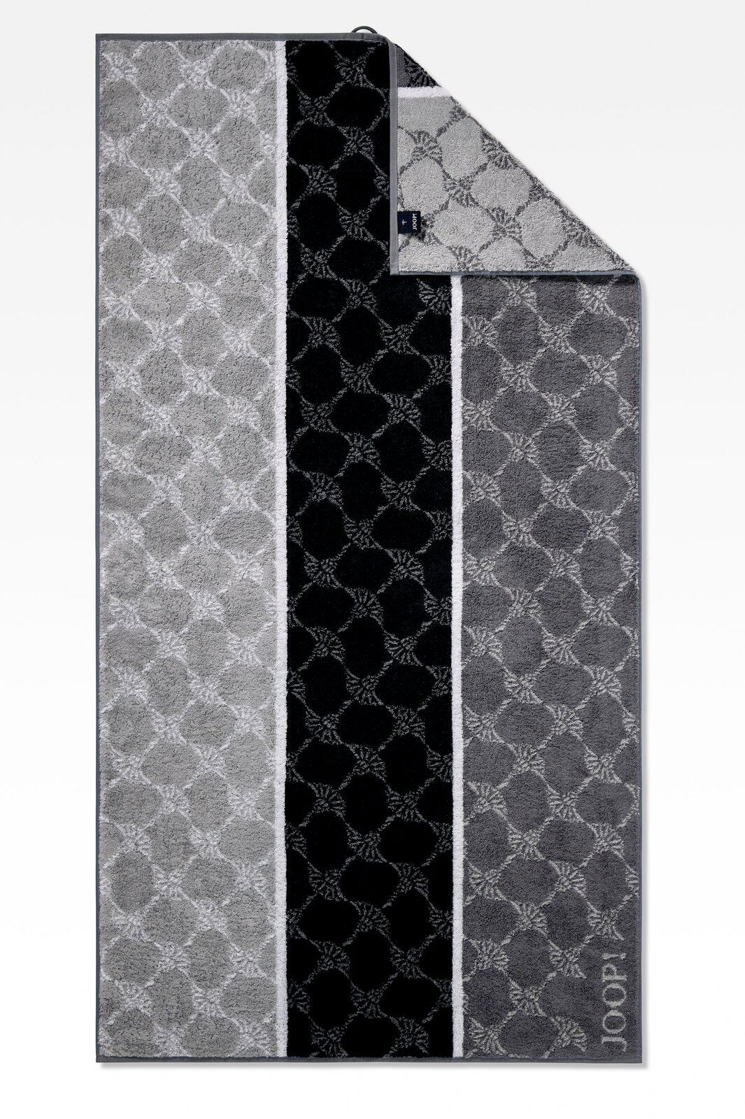 Duschtuch mit geometrischem Muster in Grautönen, von oben fotografiert