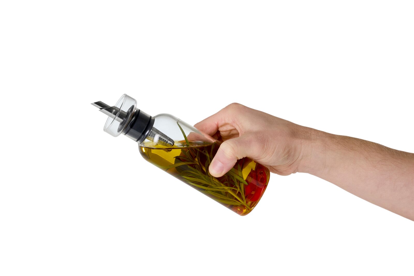 Schräg von der Seite: Hand hält eine transparente Glas-Ölflasche mit Ausgießer, gefüllt mit Kräuteröl mit Rosmarin und Chilischoten vor weißem Hintergrund