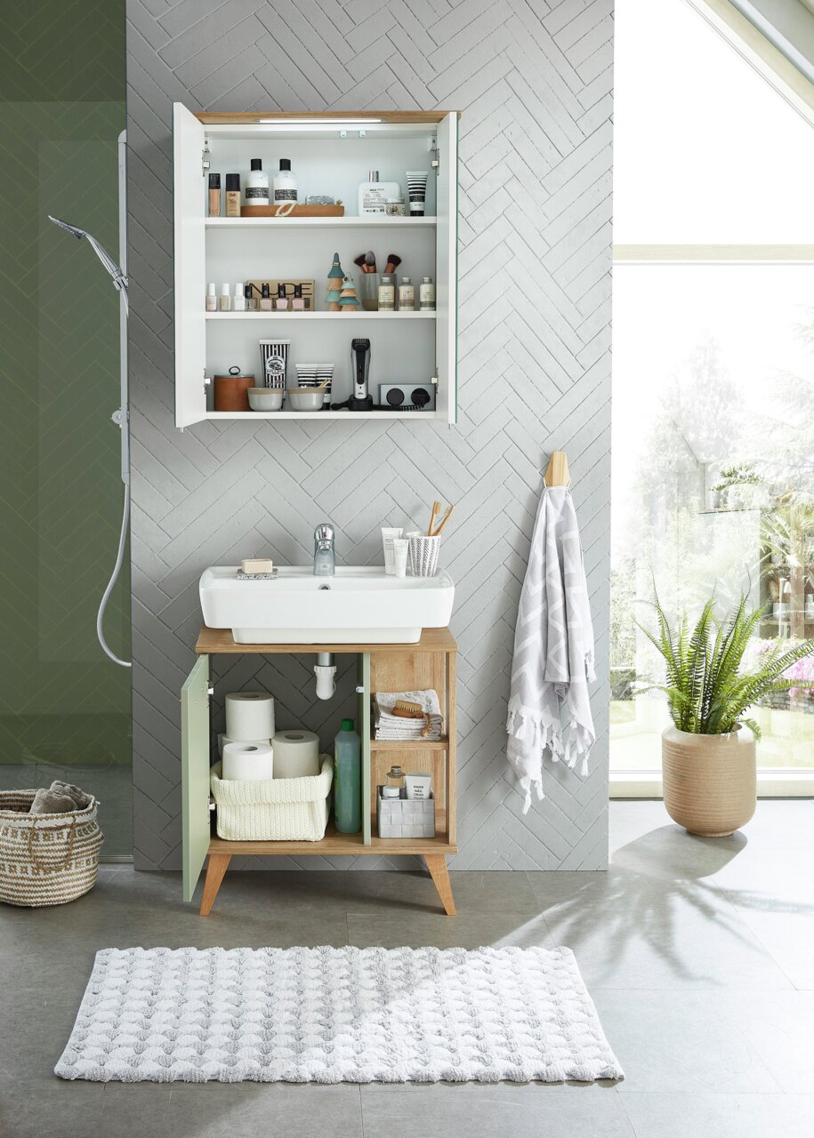 Moderner Spiegelschrank im Badezimmer, frontal fotografiert, mit offenen Türen, gefüllt mit Pflegeprodukten und Accessoires.