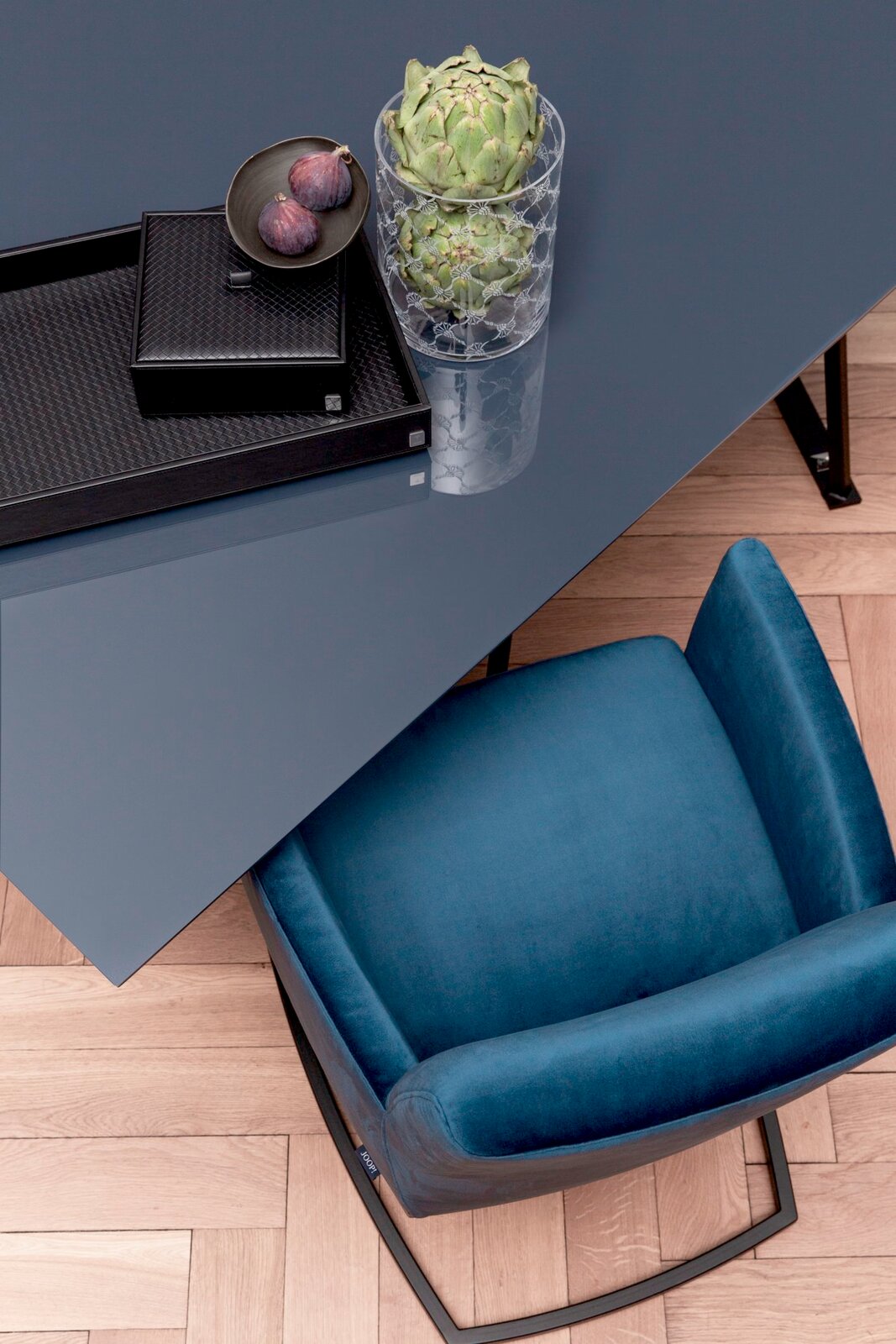 Freischwinger-Sessel in Blau aus der Vogelperspektive neben einem Tisch mit Dekoration.