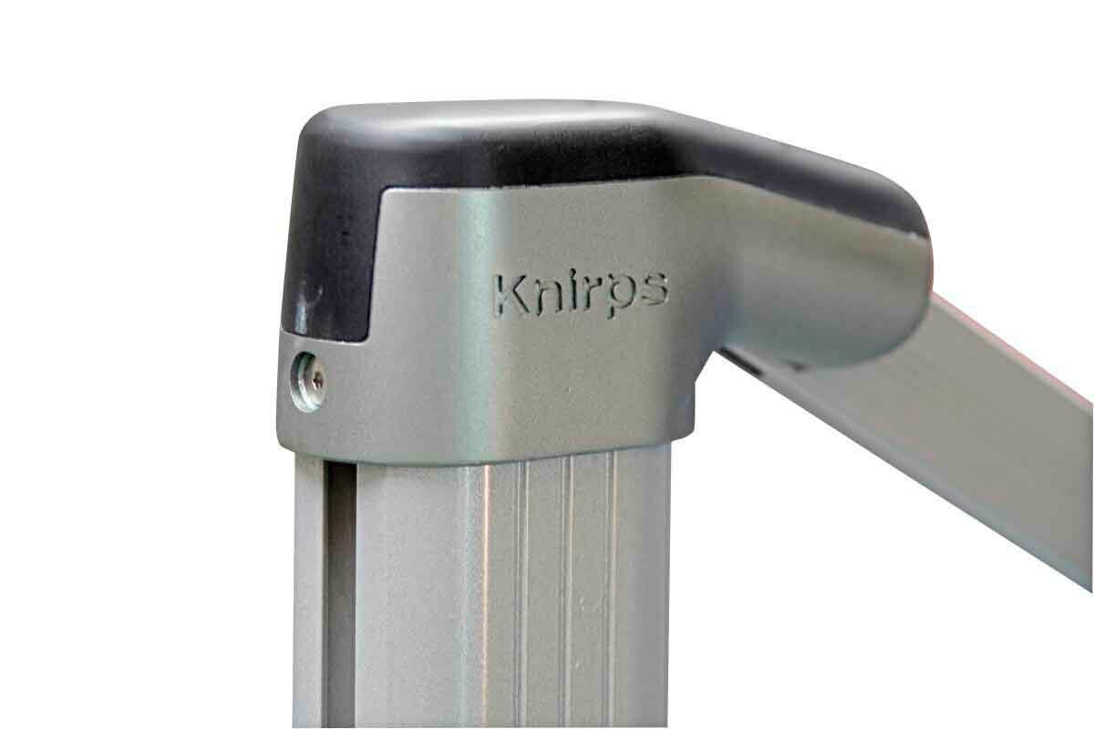 Nahaufnahme eines silbernen Gelenks eines Pendelschirms mit der Aufschrift 'Knirps'.