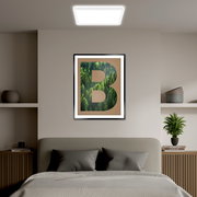 LED-Paneel an der Decke eines modern eingerichteten Schlafzimmers, frontal betrachtet.