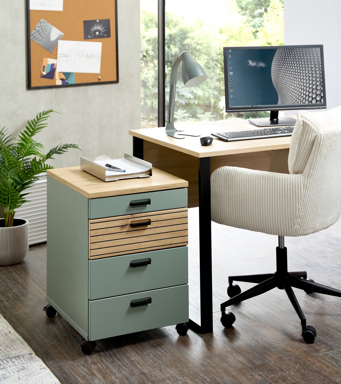 Rollcontainer mit drei Schubladen, aus Holz und Metall, auf Rollen, neben einem Schreibtisch in einem modernen Büro, seitliche Perspektive.