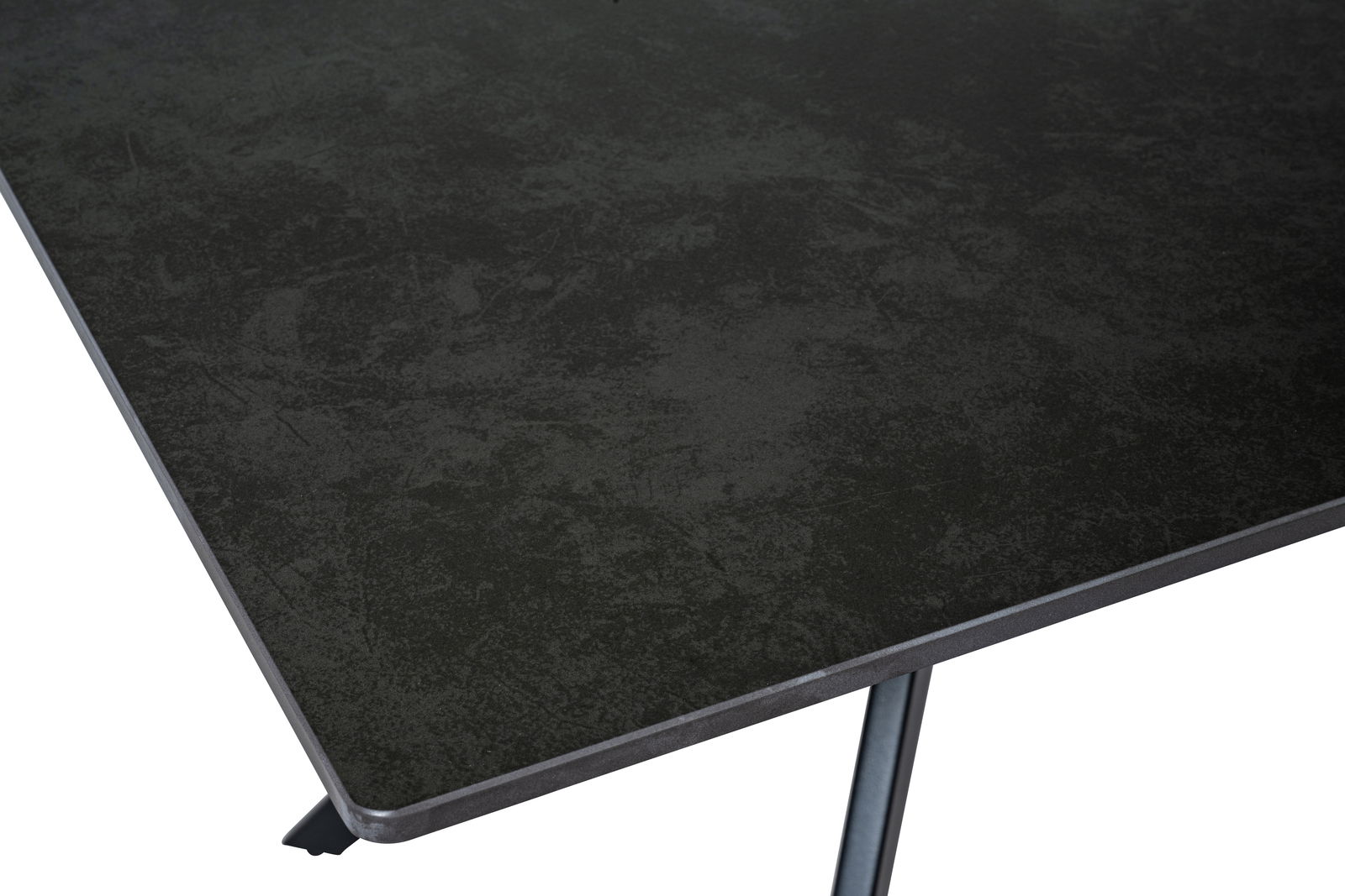 Nahaufnahme einer dunklen Tischplatte mit strukturierter Oberfläche, perspektivisch von oben rechts fotografiert.