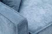 Nahaufnahme eines blauen Funktionssofas mit strukturiertem Stoffbezug, Blick auf die Armlehne und Sitzfläche.