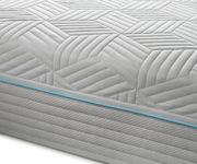 Nahaufnahme einer Gel-Kaltschaummatratze mit geometrischem Muster und blauer Ziernaht, seitliche Perspektive.