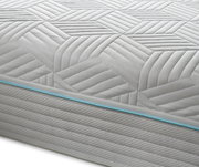 Nahaufnahme einer Gel-Kaltschaummatratze mit geometrischem Muster und blauer Ziernaht, seitliche Perspektive.