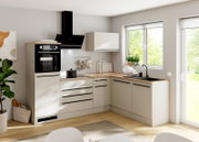 Moderne L-vormige keuken in mat wit met houtlook werkblad, zwarte grepen, inbouwoven, kookplaat en spoelbak, gezien schuin van voren.