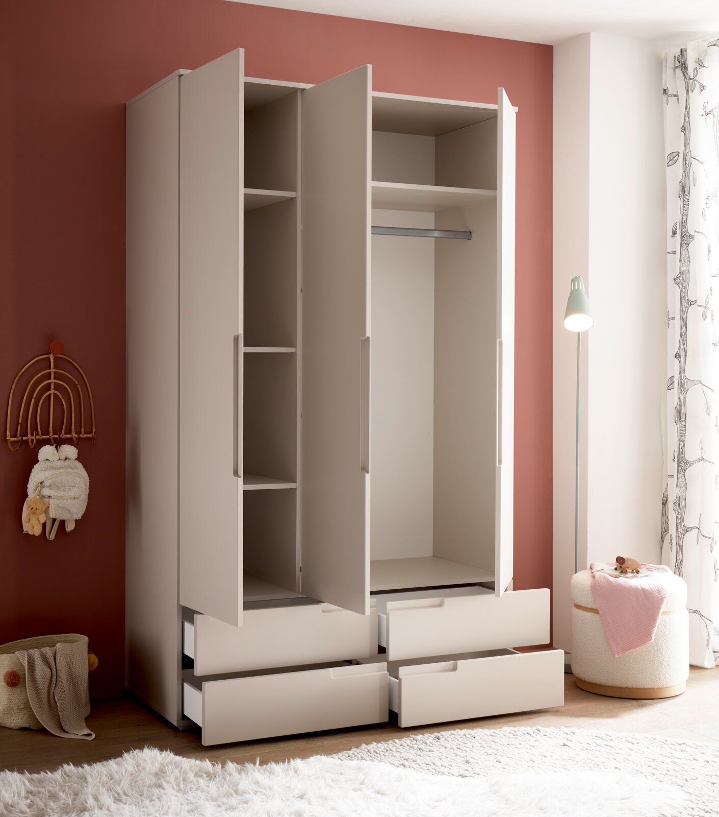 Weißer Kleiderschrank mit drei geöffneten Türen und vier ausgezogenen Schubladen, Innenfächer und Kleiderstange sichtbar, fotografiert in leicht schräger Frontansicht im Kinderzimmer.