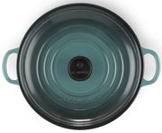 Obere Ansicht einer runden, türkisfarbenen Servierpfanne mit zwei Griffen und einem schwarzen Knauf auf dem Deckel.