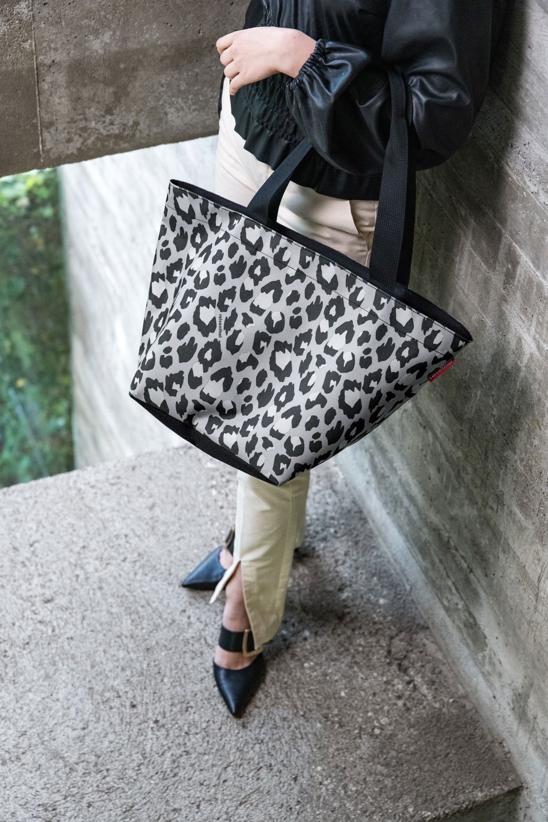 Leopardenmuster Shopper-Tasche in Schwarz-Weiß, getragen von einer Person in seitlicher Perspektive.