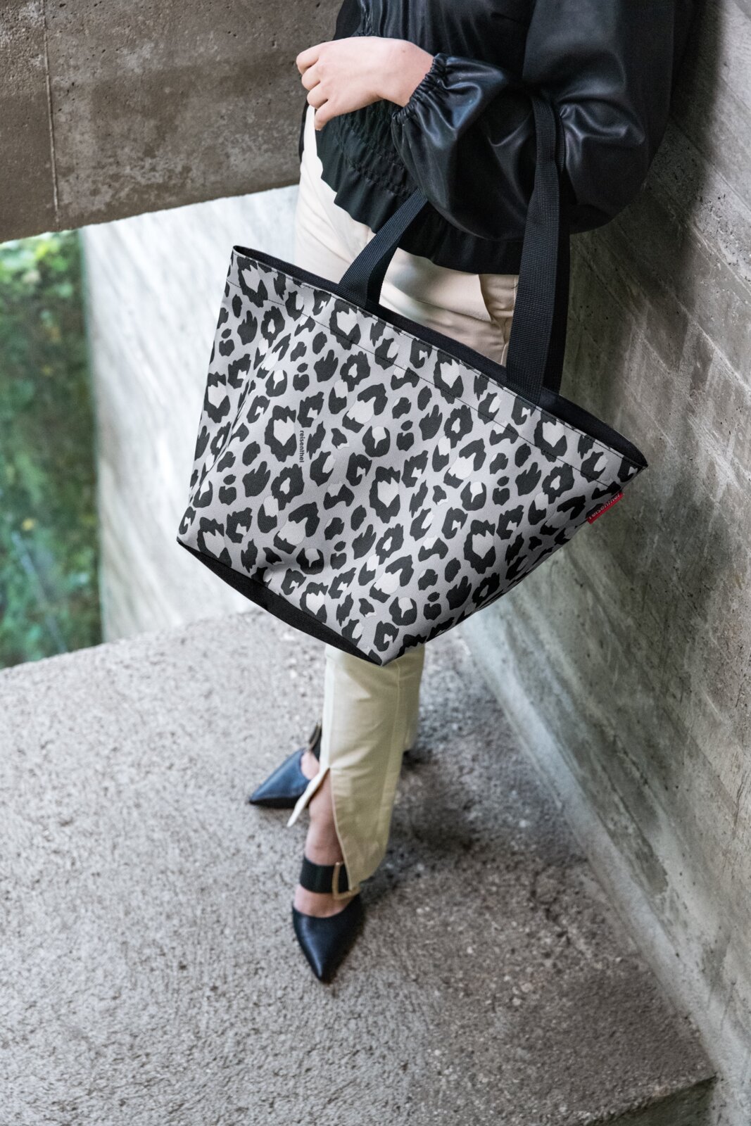 Shopper met luipaardprint in zwart-wit, gedragen door iemand in zijaanzicht.