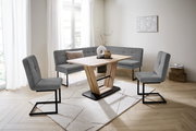 Moderne Esszimmer-Eckbankgruppe mit grauen Polstern und Holztisch in einem hellen Raum, seitliche Perspektive.