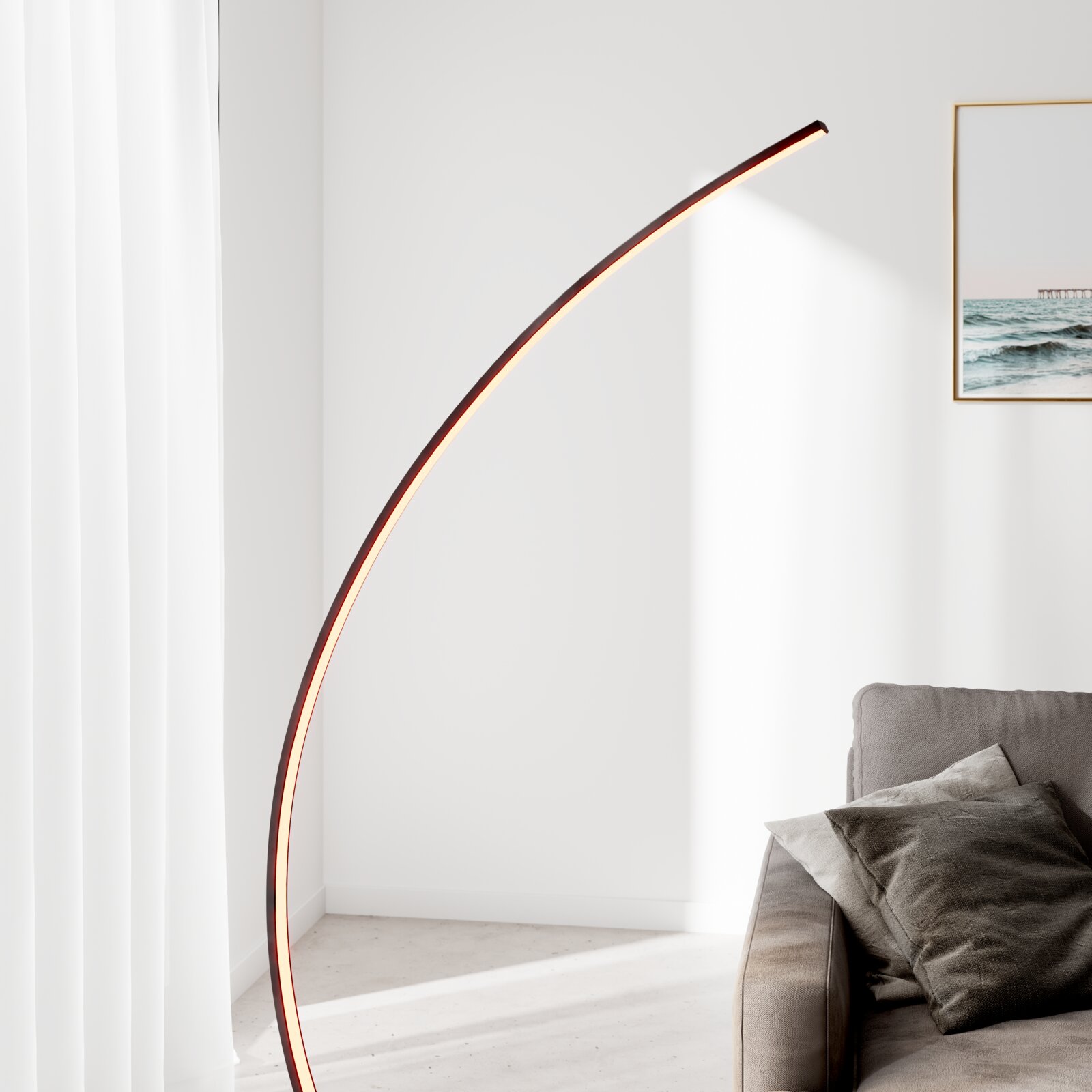 Moderne LED-Bogen-Stehlampe mit schlankem, gebogenem Lichtband in warmweiß neben einem grauen Sofa im hellen Wohnzimmer, perspektivisch in seitlicher Ansicht von leicht unten.