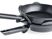 Zwei übereinander gestapelte Pfannen mit grauen Filz-Pfannenschützern dazwischen, seitliche Perspektive