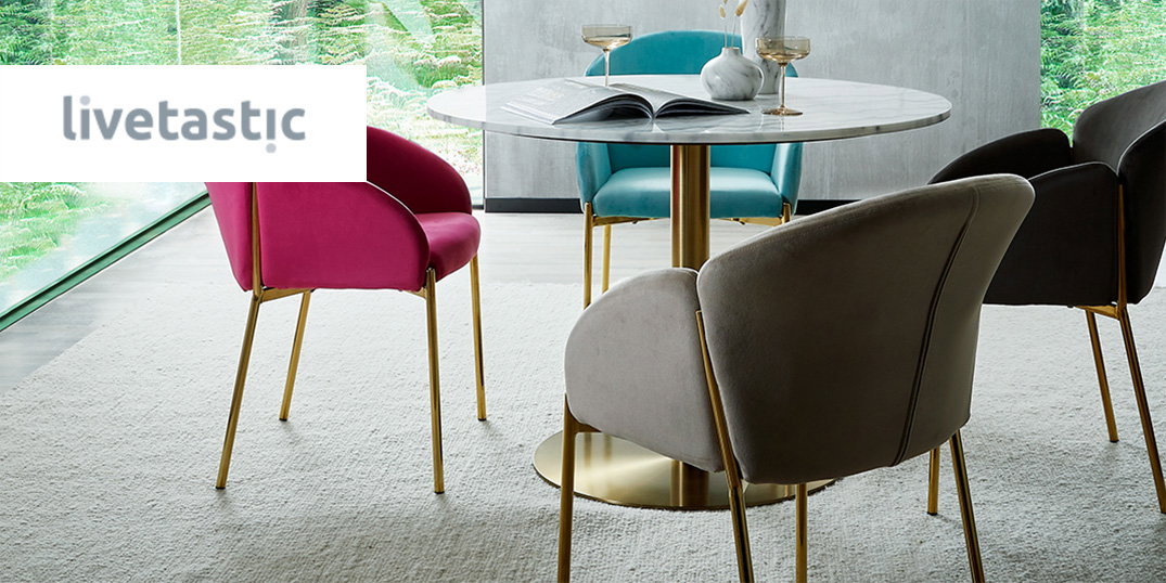 Eethoek met een ronde marmeren tafel en stoelen in roze, blauw en grijs met een gouden frame. Logo Livetastic