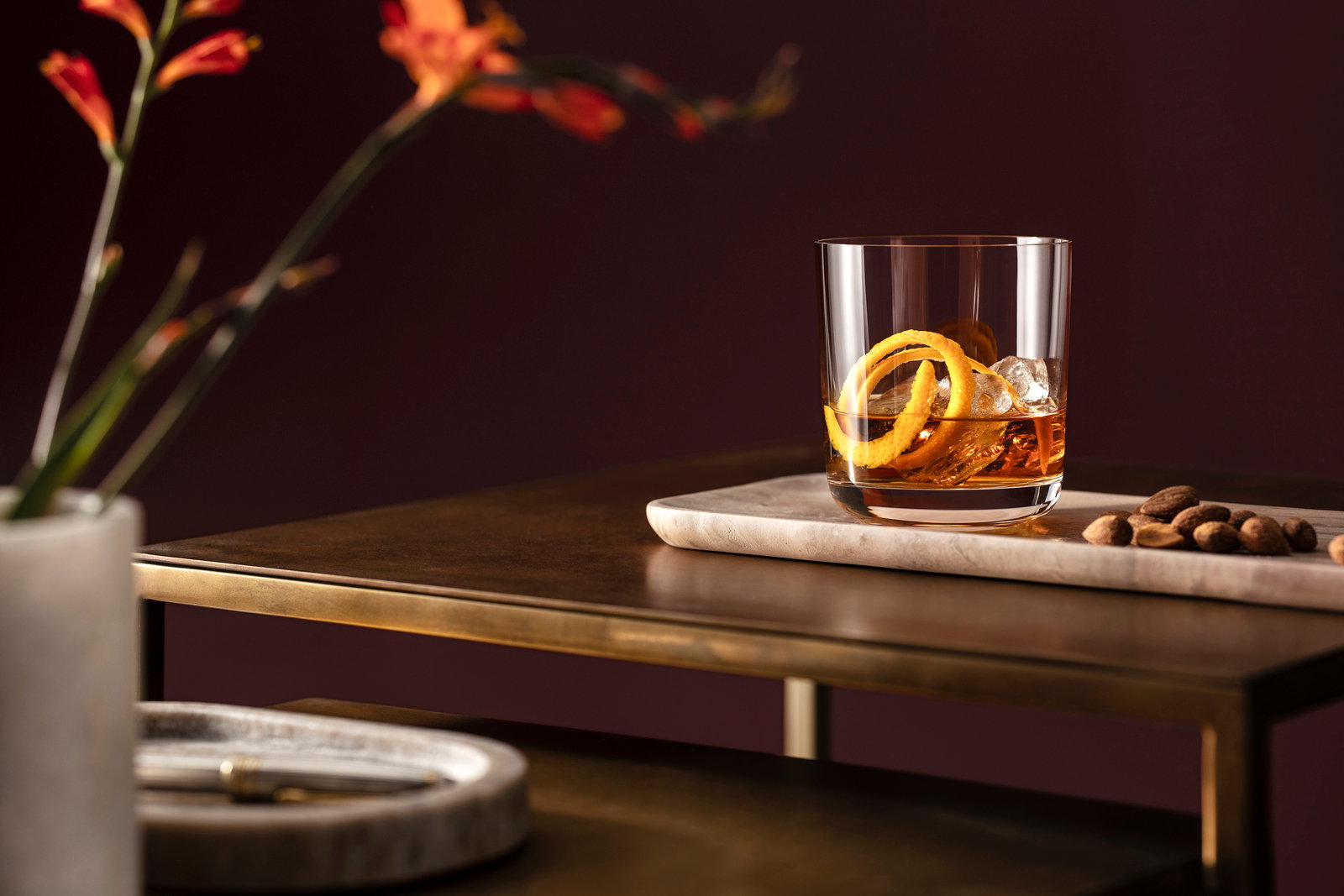 Villeroy & Boch Whiskyglazen, set van 4, LA DAVINA Whiskyglas mit Eiswürfeln und Orangenschale auf einem Tisch, seitliche Perspektive