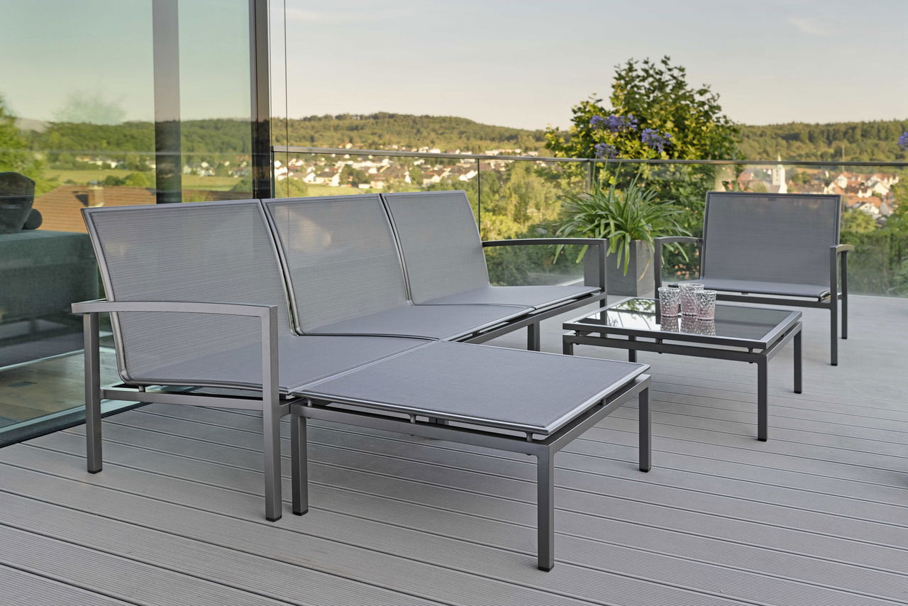 Moderne Outdoor-Lounge-Möbel auf einer Terrasse mit Blick auf die Landschaft, Perspektive von der Seite.