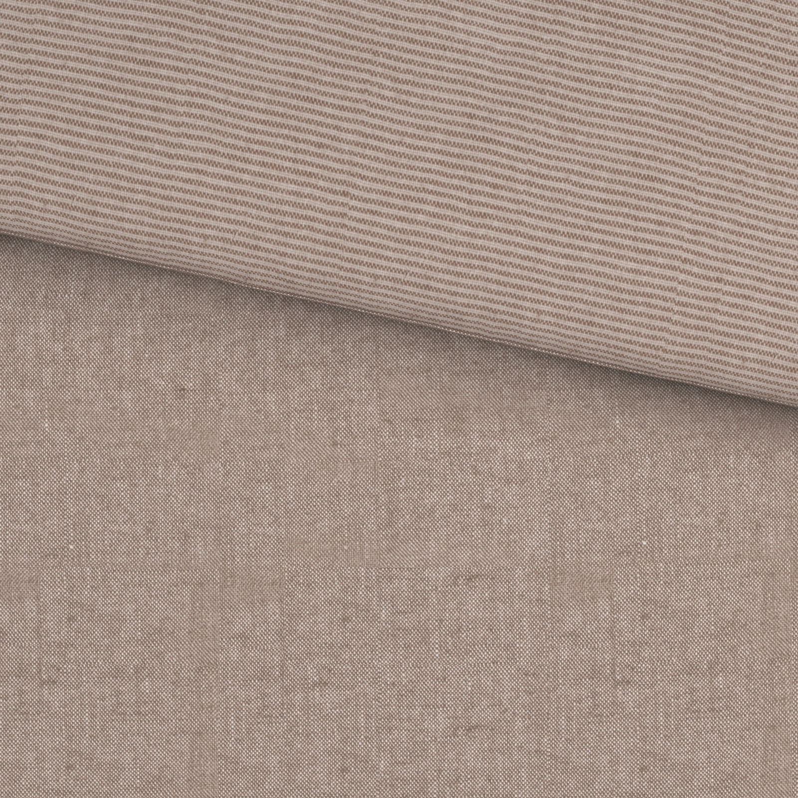 Nahaufnahme einer Wendebettwäsche mit einer Seite in feinem Streifenmuster und der anderen in einfarbigem Design.