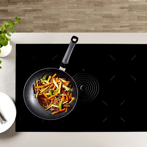 Wokpfanne Adamant 28cm auf einem Herd von oben mit Gemüse gefüllt