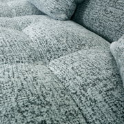 Close-up van een gestructureerd, gestoffeerd oppervlak van een grijze bank, gezien van bovenaf.