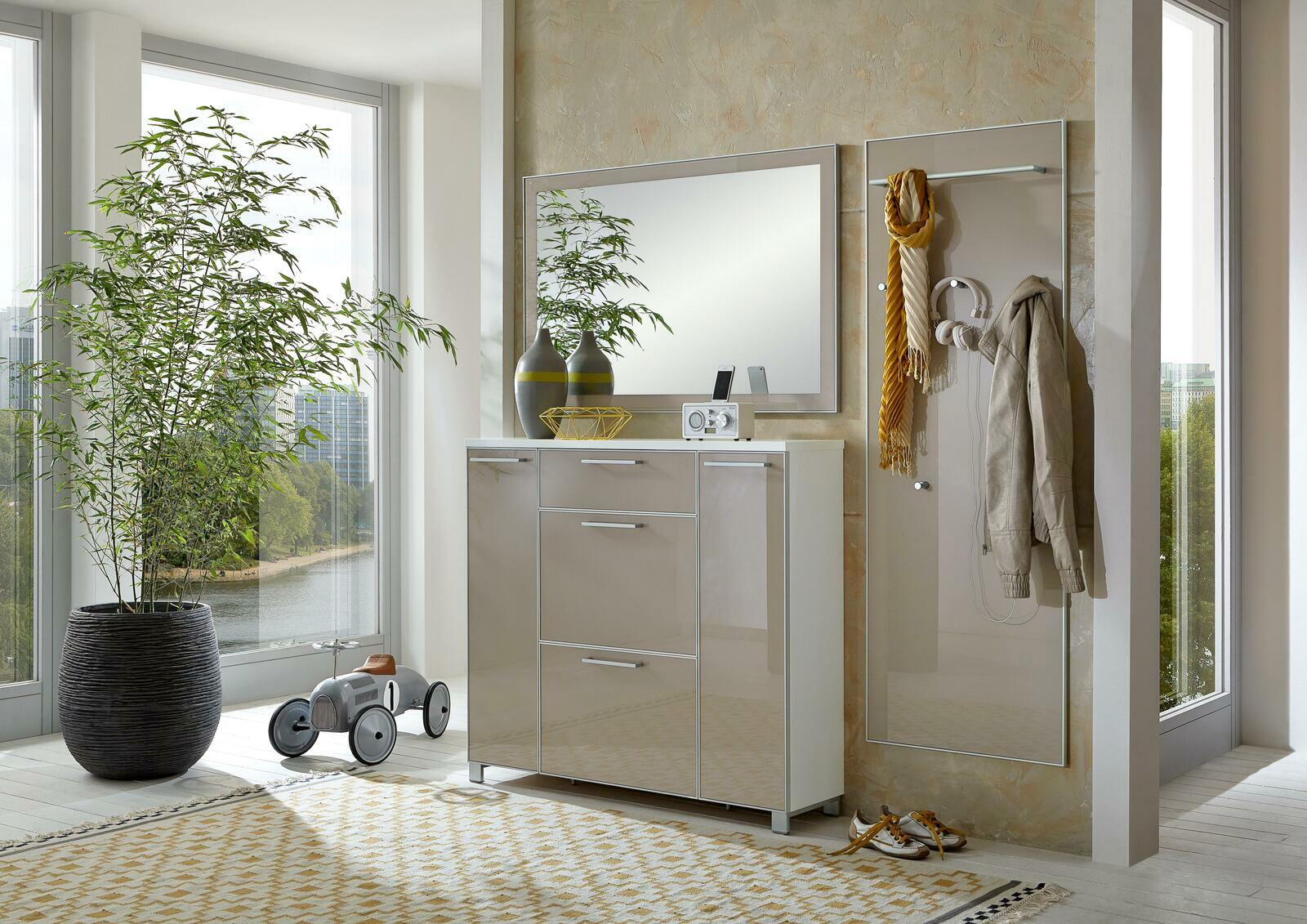 Moderne Garderobeneinrichtung mit Spiegel, Schuhschrank und Garderobenpaneel in einem hellen Raum mit großen Fenstern, seitliche Perspektive.