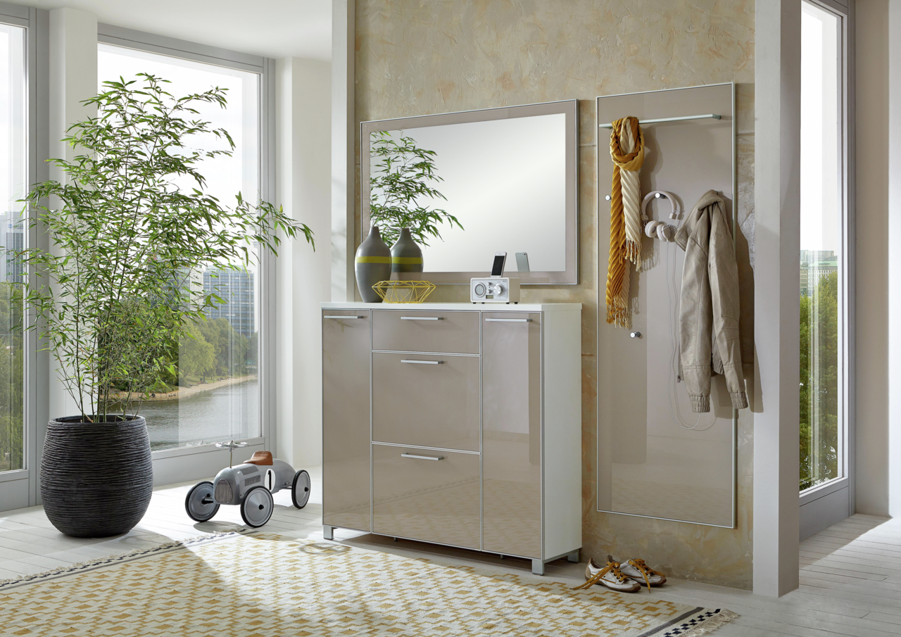 Moderne Garderobeneinrichtung mit Spiegel, Schuhschrank und Garderobenpaneel in einem hellen Raum mit großen Fenstern, seitliche Perspektive.