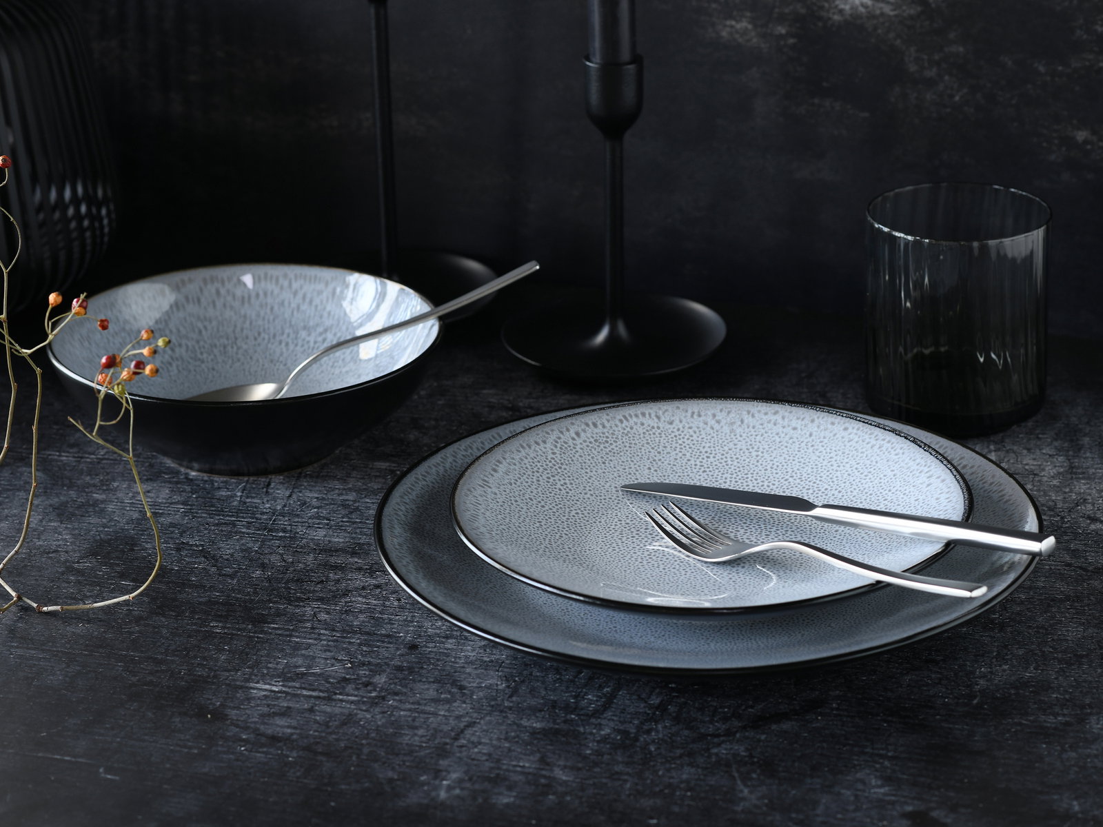 Elegantes Kombiservice 16-tlg in dunklem, modernem Design mit Teller, Schale und Besteck, seitliche Perspektive.