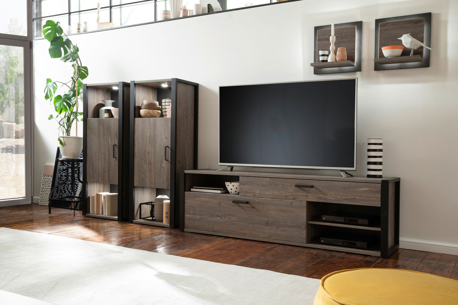 Wohnzimmeransicht mit modernem Highboard und TV-Schrank in dunkler Holzoptik, seitliche Perspektive