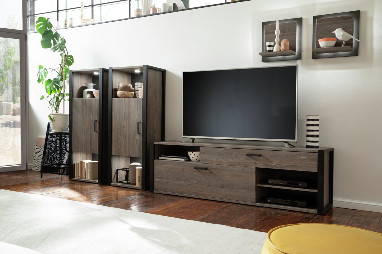 Zicht op de woonkamer met een modern hoogkast en tv-meubel in donkere houtlook, zijaanzicht