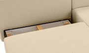 Nahaufnahme eines Schlafsofas in L-Form mit Stauraum unter der Sitzfläche, Perspektive von oben.