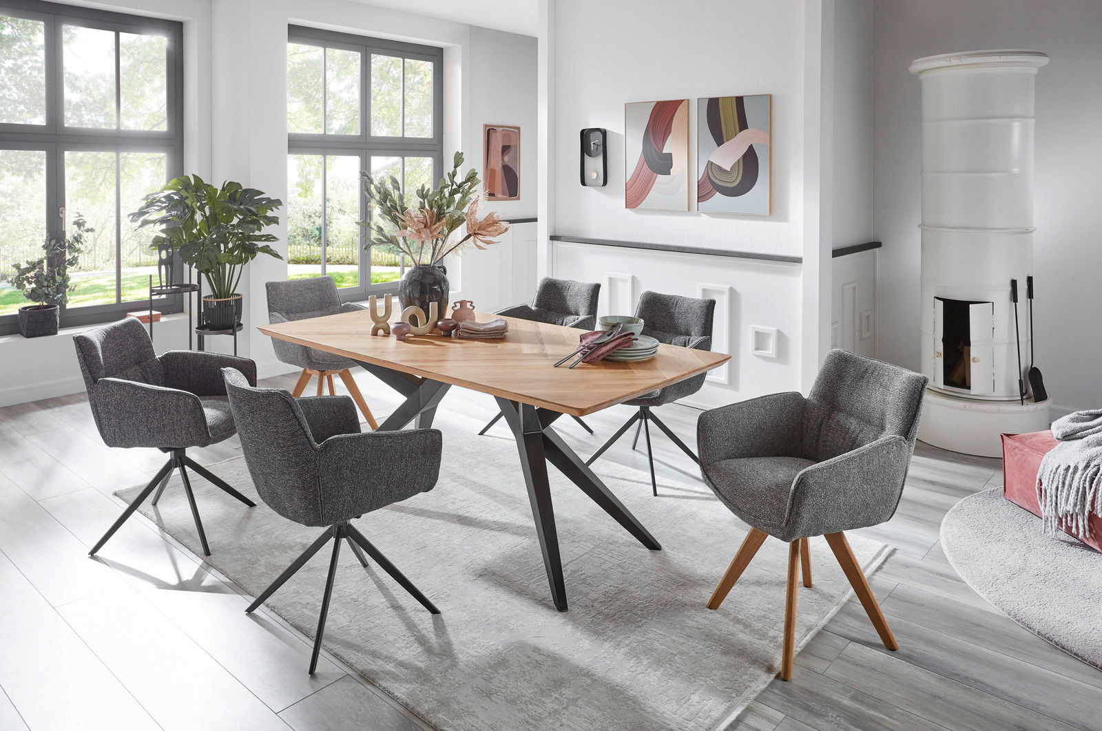 Valdera Armlehnstuhl DORI Moderner Essbereich mit sechs grauen Armlehnstühlen um einen Holztisch, seitliche Perspektive.