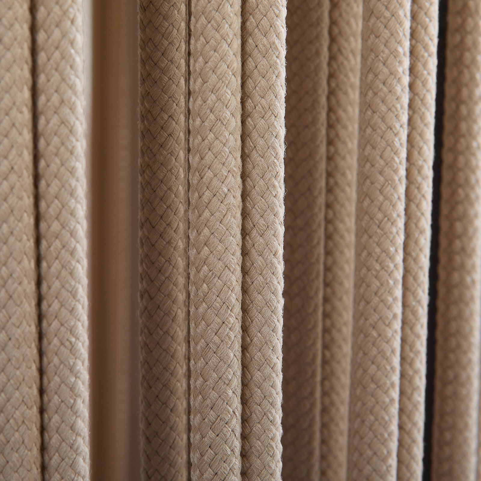 Nahaufnahme von geflochtenem Seilmaterial in beiger Farbe, vertikale Perspektive