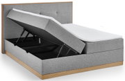 Boxbed met grijze stoffen bekleding en houten frame, zijaanzicht, met opgevouwen matras voor toegang tot de opbergruimte